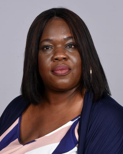 A portrait of a woman is standing in front of a white background.